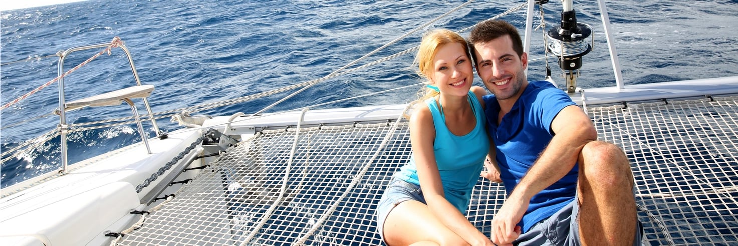 A couple snuggle on the back of their yacht in a Massachusetts waterway