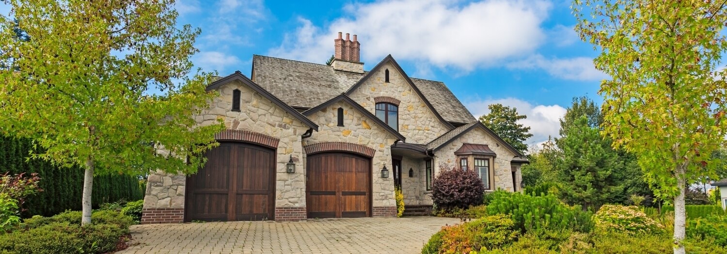 A rustic stone-front high-value home with two garages