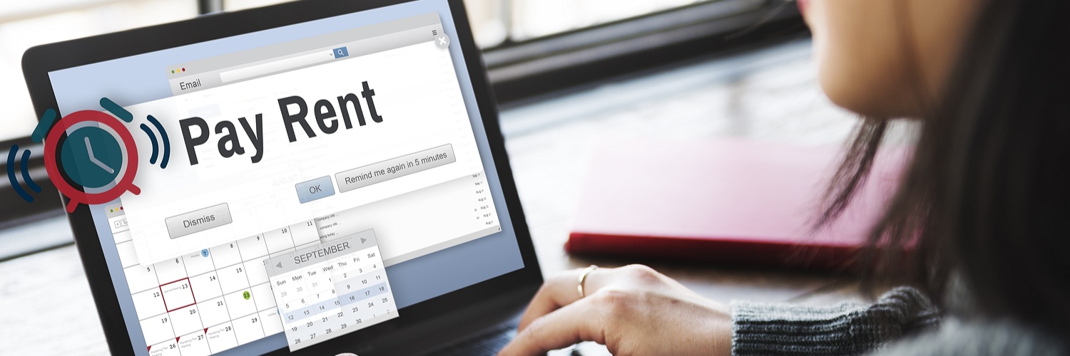 A woman on her laptop computer with a 'Pay Rent' notification